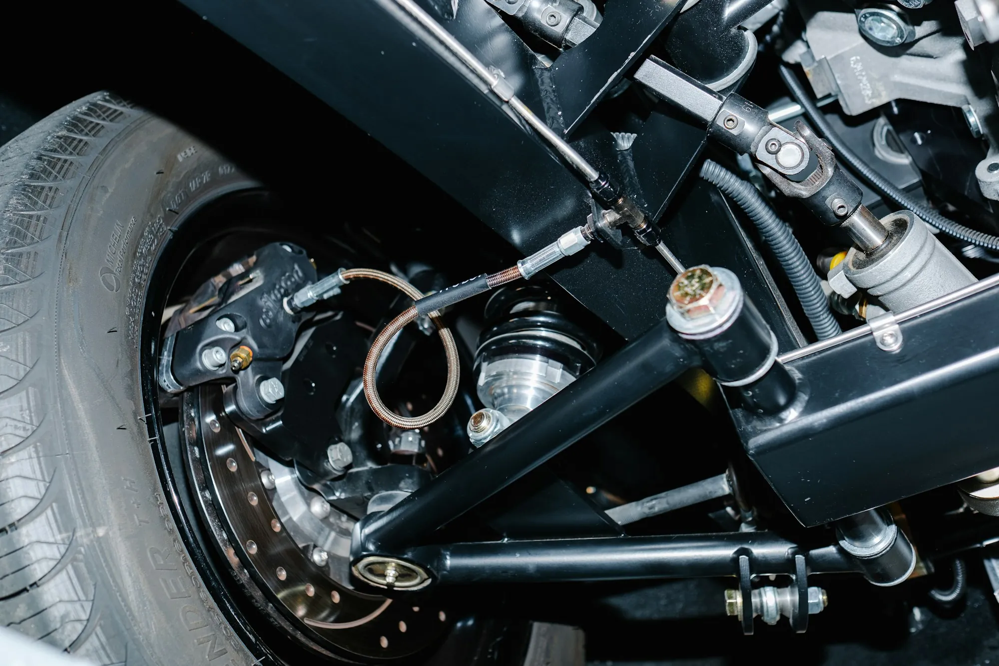 Close view of a vehicle's suspension arm, spring and brake assembly